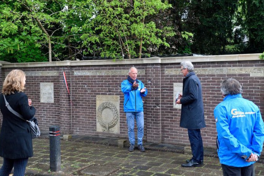 Hans van Harten, gildegids, geeft burgemeester Bolsius bij het oorlogsmonument aan de Appelweg een toelichting op het woensdag gepresenteerde wandelboekje 'Verloren vrijheid herwonnen'